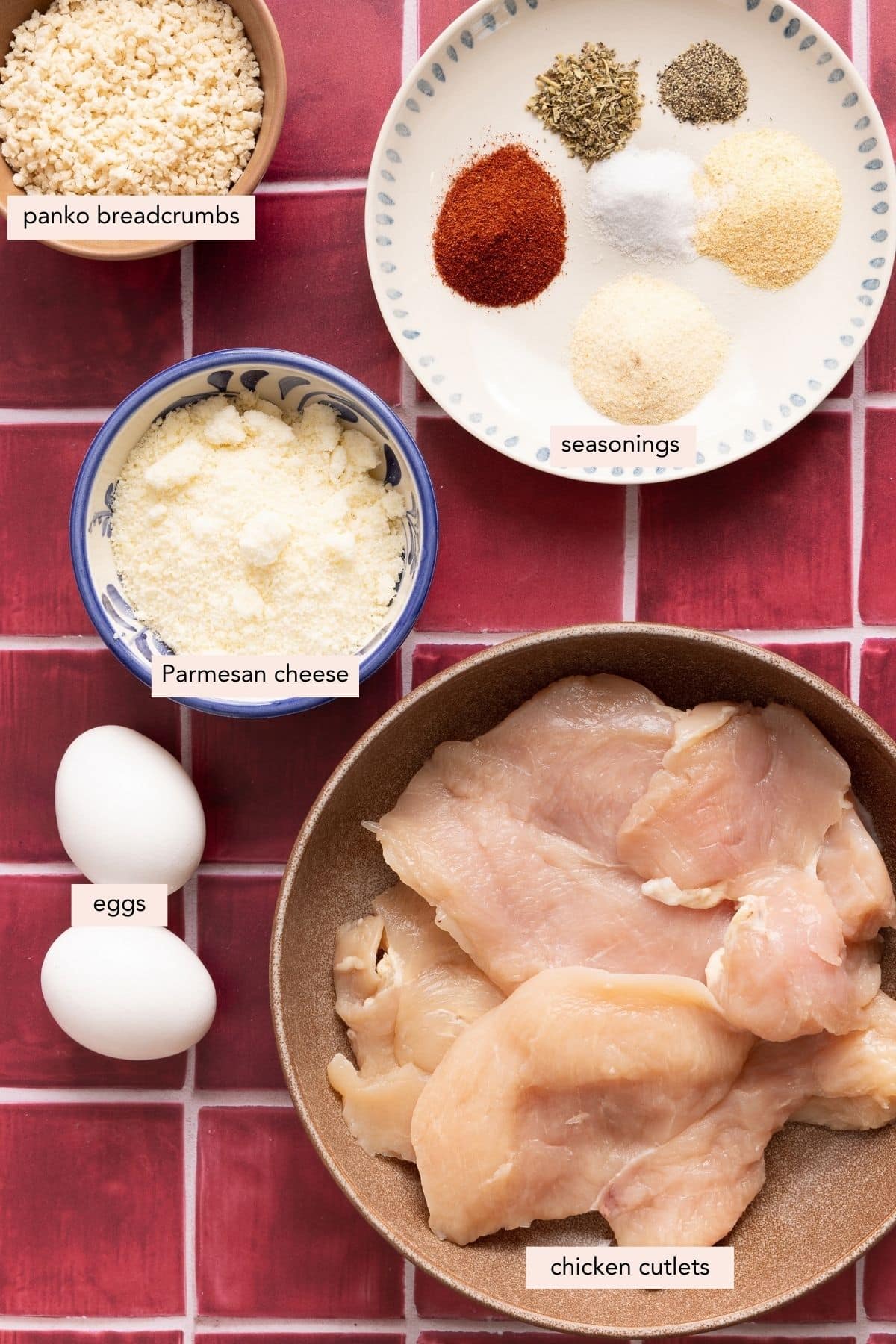 All of the ingredients for air fryer chicken cutlets in bowls on a countertop.