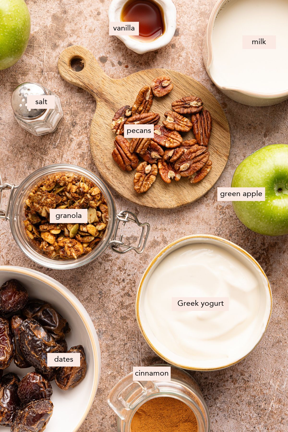 Ingredients for protein caramel apple parfaits on a countertop with labeled ingredients.
