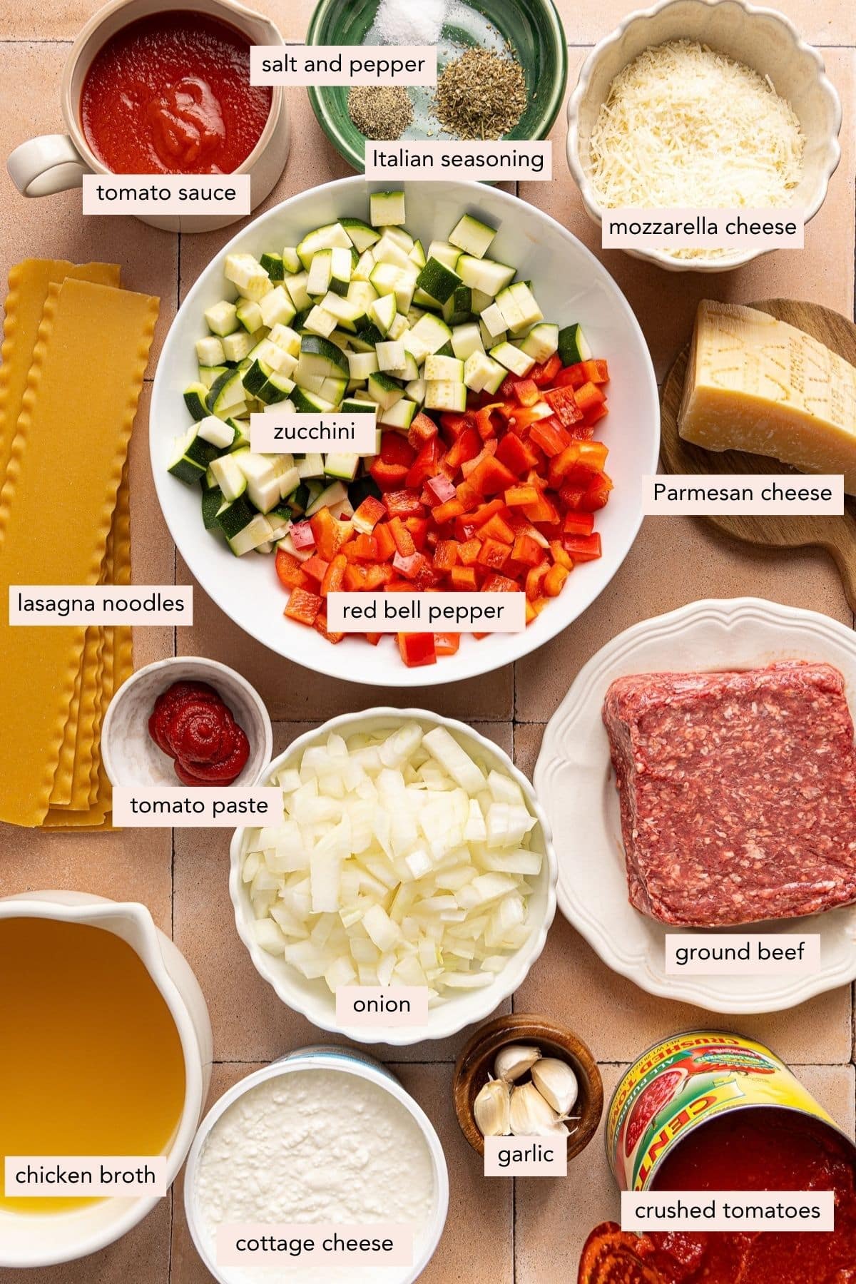All of the ingredients for slow cooker lasagna soup in bowls on a countertop.