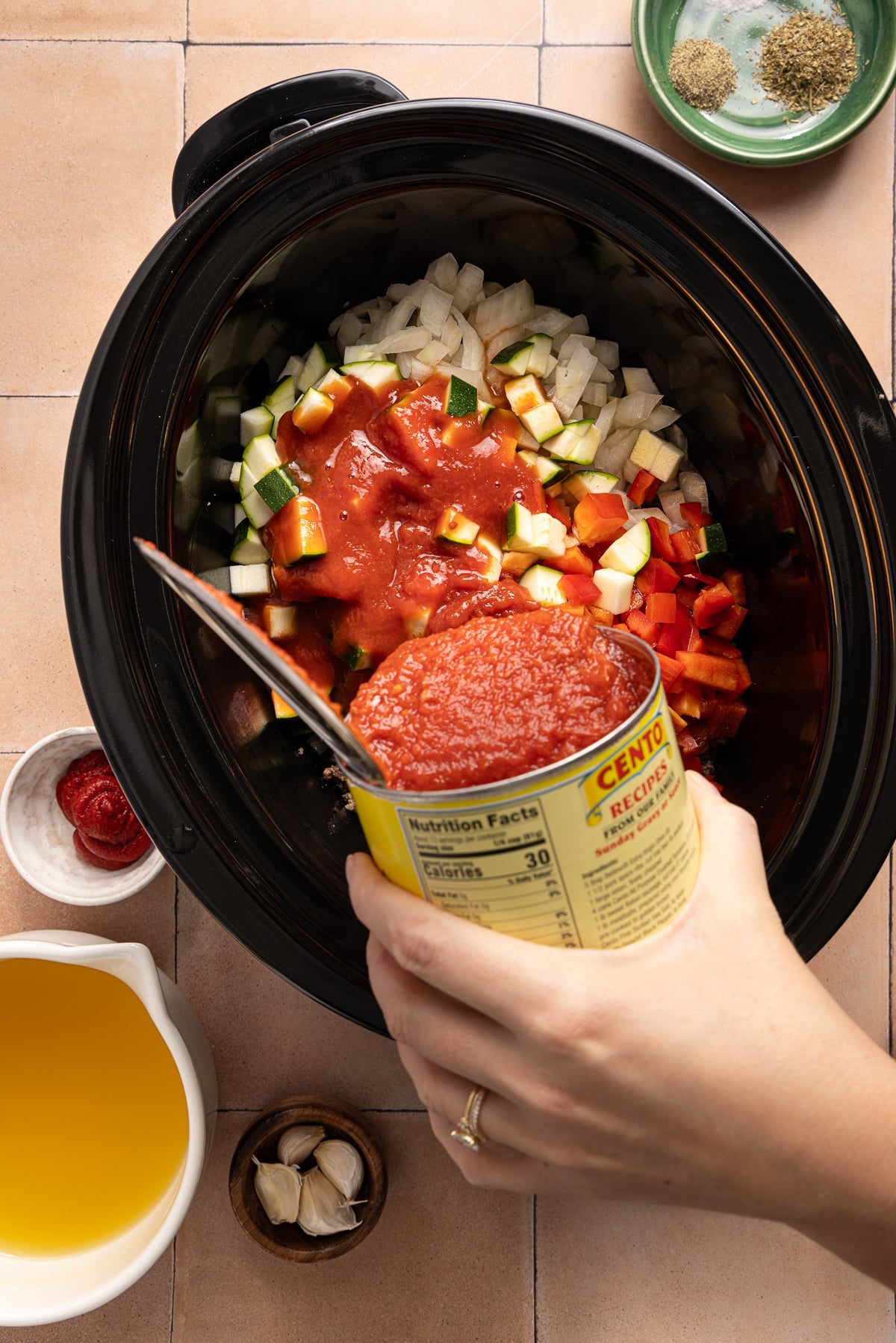 Pouring the remaining ingredients except for the lasagna noodles into the slow cooker.