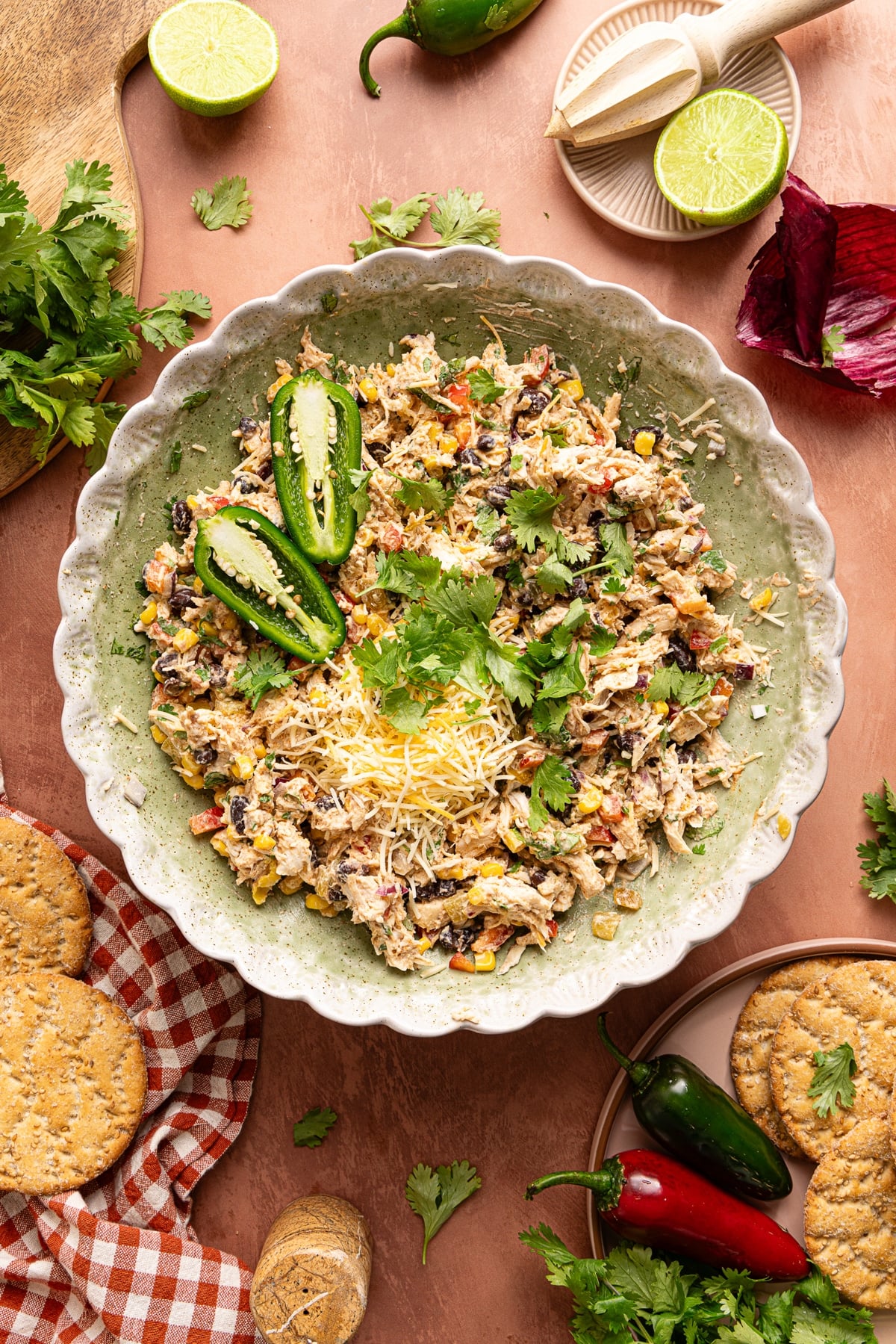 The southwest chicken salad in a bowl garnished with a sliced avocado, fresh cilantro, and shredded mexican cheese blend.